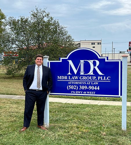 Michael In Front Of Firm Sign
